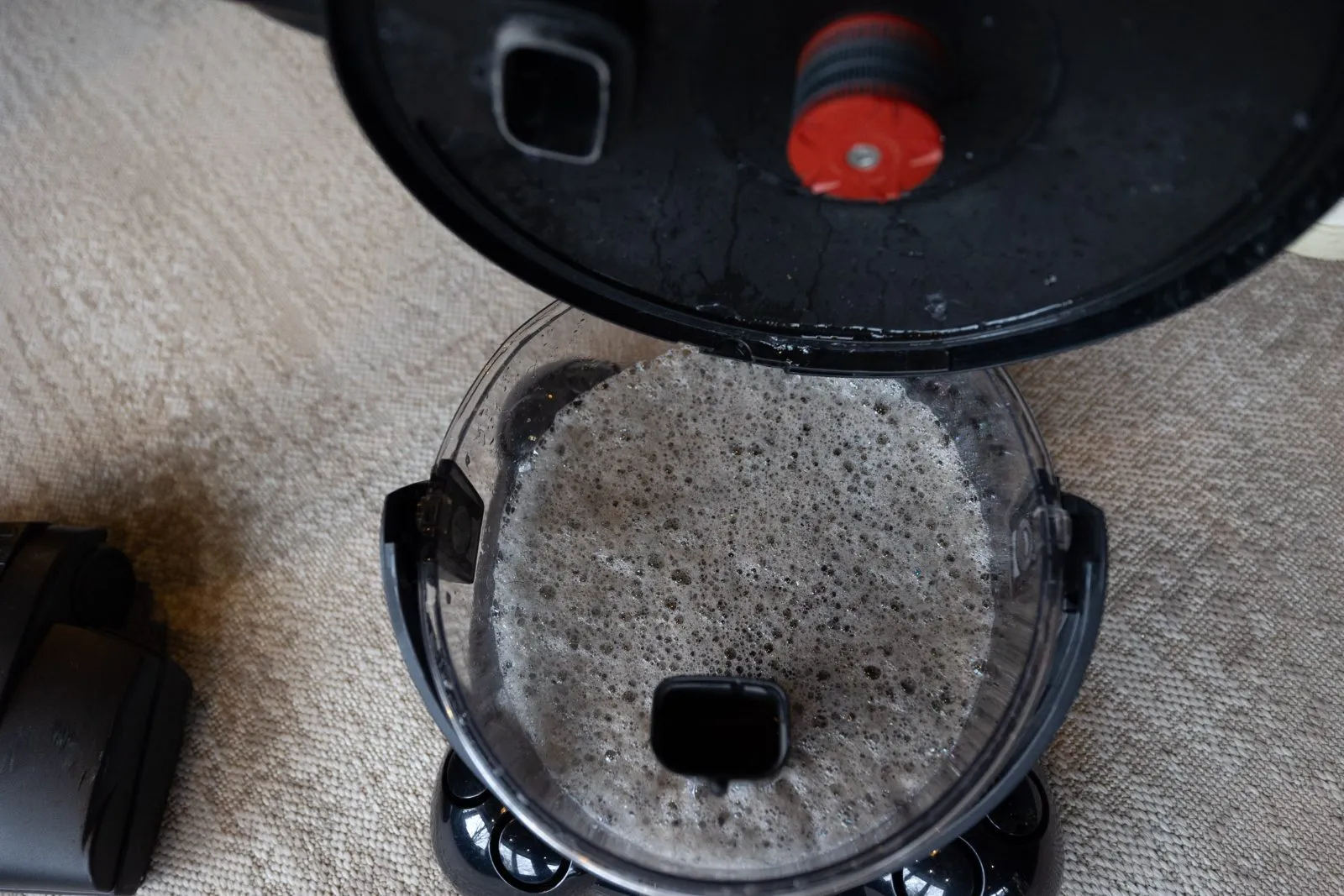 Geöffneter HYLA Wasserbehälter mit gebundenem Staub nach dem Saugen